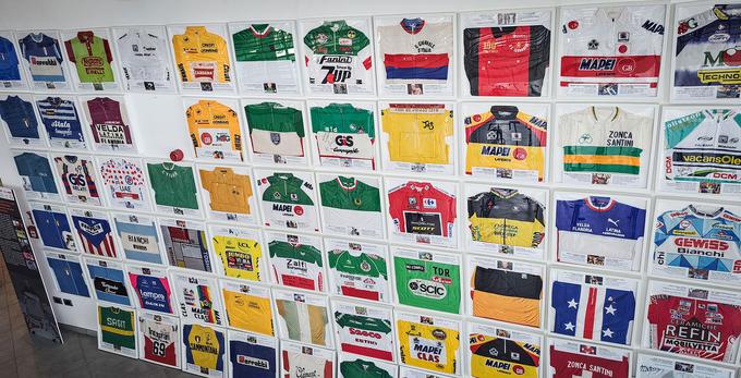 Zbirka kolesarskih majic iz različnih dirk, med njimi je tudi pikčasta majica Tadeja Pogačarja s Toura in rumena majica Jonasa Vingegaarda. | Foto: Alenka Teran Košir