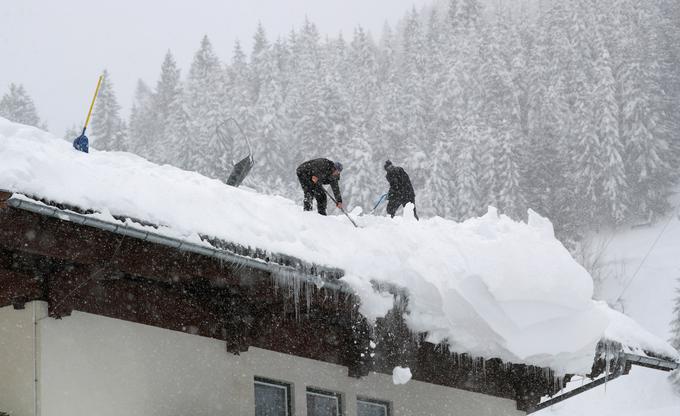 V Avstriji imajo trenutno veliko dela tudi s čiščenjem snega s streh stavb, ki bi se pod težo debele snežne odeje lahko tudi vdale. | Foto: Reuters