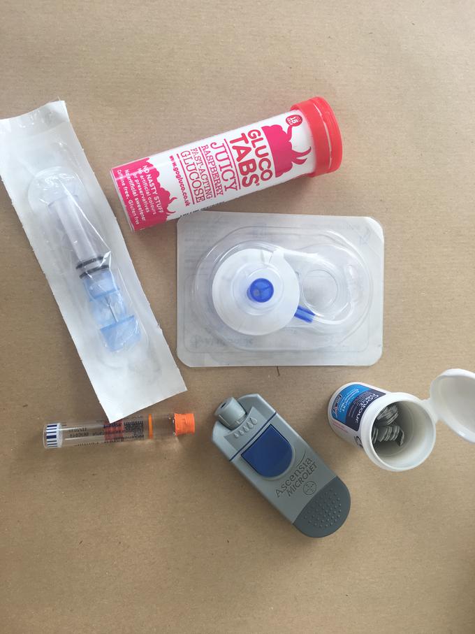 Na sliki: glukozne tablete, testni lističi, steklenička inzulina, naprava, s katero se zbode v prsti, da si izmeri sladkor, igla in set, ki ga Maruša vstavi v predel trebuha ter poveže z inzulinsko črpalko.  | Foto: Maša K. Brecelj