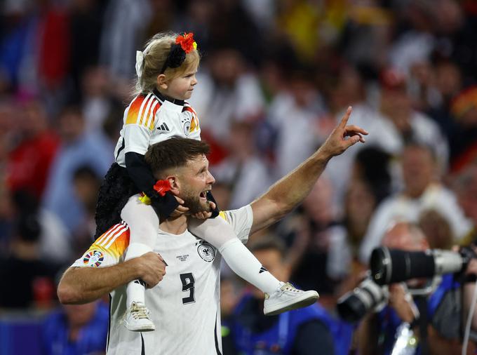 Niclas Füllkrug je visoko zmago Nemčije proslavil s hčerko na ramenih. | Foto: Reuters