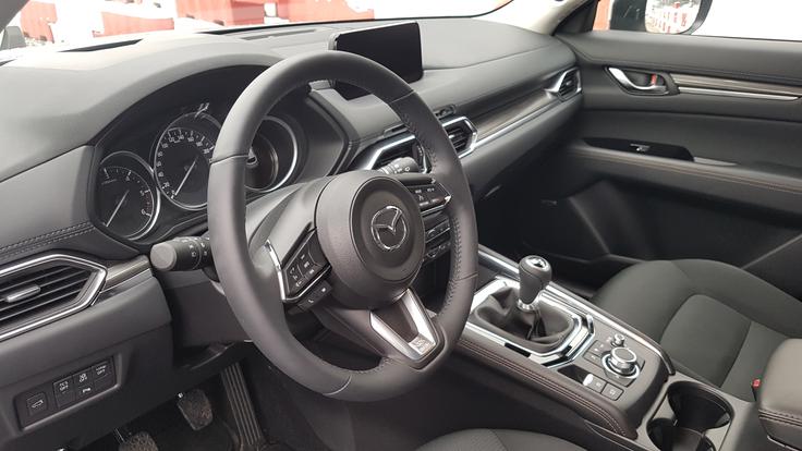 Mazda ima na sredinskem grebenu okrogel gumb za nadzor infozabavnega vmesnika, saj zaslon med vožnjo ni občutljiv na dotik. Hvalimo skrb za prometno varnost. Tak vrtljiv gumb poznamo predvsem iz premium razreda. | Foto: Gregor Pavšič