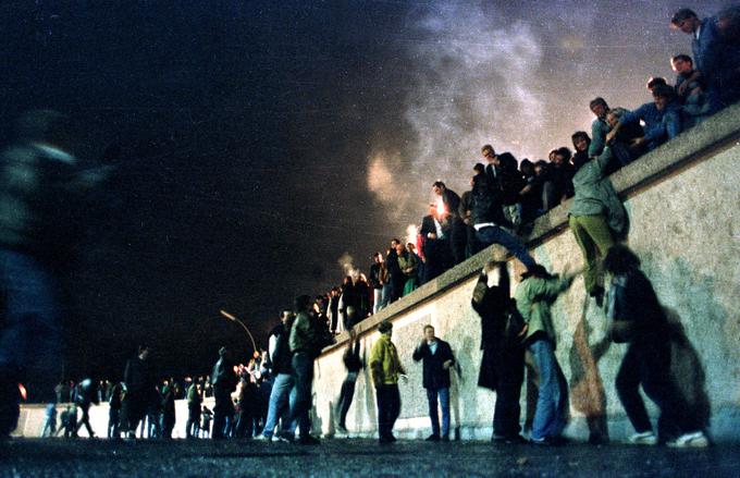 Prebivalci vzhodnega dela mesta so se v noči na 10. november takole povzpeli na zid, ki je prej delil mesto. | Foto: Reuters