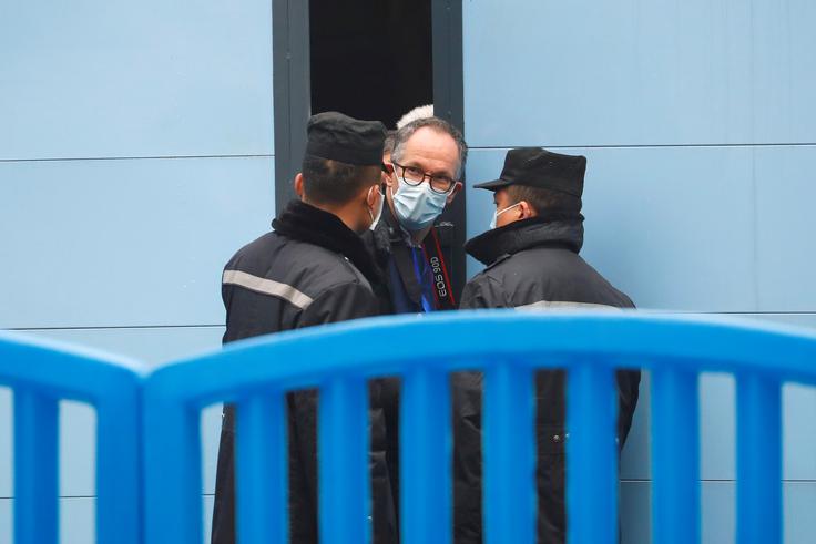 Svetovna zdravstvena organizacija (WHO) je januarja letos na Kitajsko poslala skupino znanstvenikov. Ti so si pod budnim očesom kitajskih gostiteljev in ob strogih varnostnih ukrepih ogledali tudi tržnico z morskimi sadeži v Wuhanu, ki naj bi bila prvo žarišče okužb. Na fotografiji vidimo enega od članov skupine znanstvenikov, Danca Petra Bena Embaraka, ki se pri vhodu v tržnico pogovarja s kitajskima varnostnikoma. | Foto: Reuters