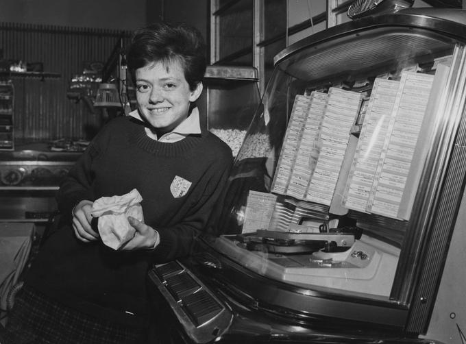 Dekle, naslonjeno na džuboks (ang. jukebox). Džuboks je bil avtomat z različnimi glasbenimi ploščami. | Foto: Getty Images