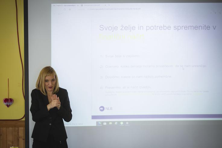 Na finančni delavnici predstavlja vez med predavateljico in obiskovalci tolmačka za gluhe, ki predavanje kaže v znakovnem jeziku. | Foto: Bojan Puhek