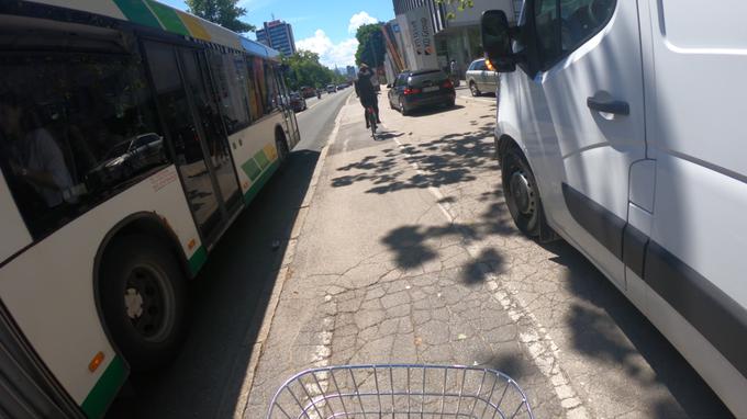 Na pločniku parkiran kombi, na levi strani istočasno mimo kolesarja mestni avtobus. Prostora ni več ostalo veliko ... | Foto: Gregor Pavšič