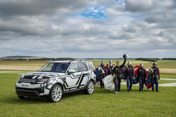 Bear Grylls z drugimi padalci ob za zdaj še zamaskiranem discoveryju. | Foto: Land Rover