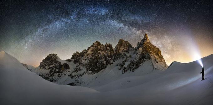 Krivina diska galaksije Rimske ceste (ne pozabite, našo galaksijo bomo vedno videli od strani, saj smo del nje - to pomeni, da je za zdaj ne moremo videti v celoti oziroma od zgoraj kot druge galaksije) se združuje s snopom alpinistove svetilke nekje v italijanskih Dolomitih. Foto: Nicholas Roemmelt. | Foto: 