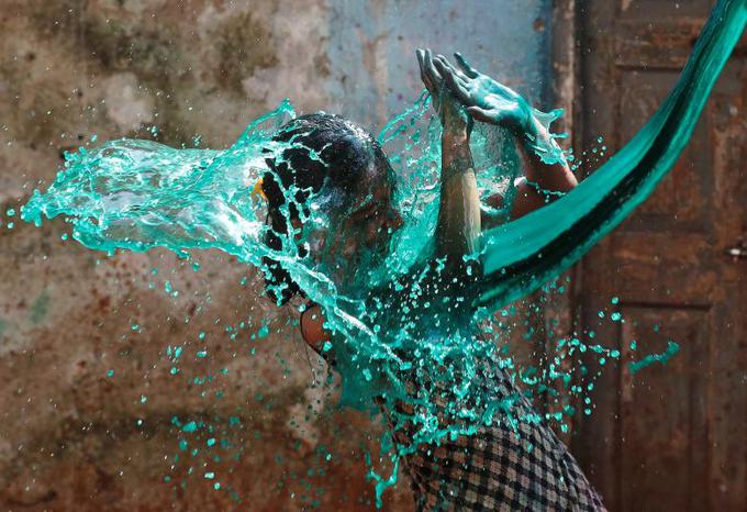 Dekletov odziv na obarvano vodo, s katero je bila zalita na Festivalu barv v Indiji. Vir: Reuters | Foto: 