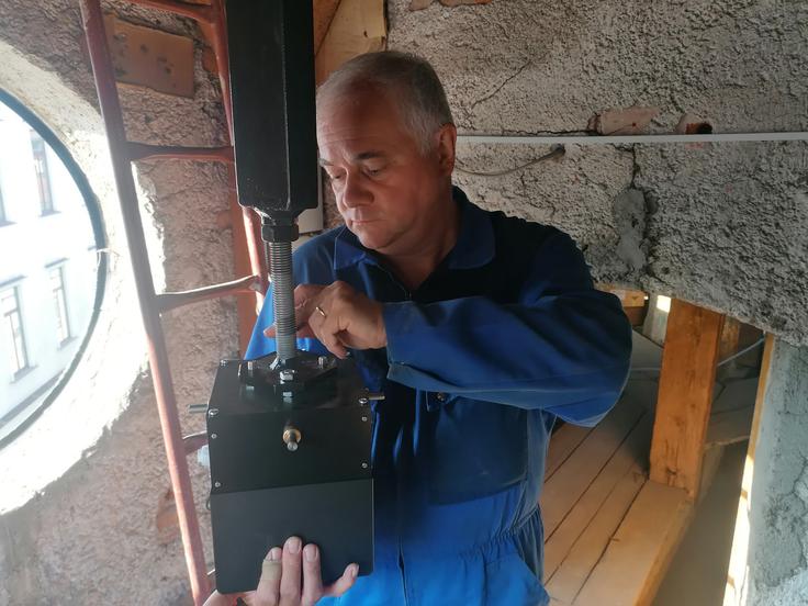 Marijan Bavcon pri postavitvi urnega pogonskega mehanizma. | Foto: Metka Rupnik/STA