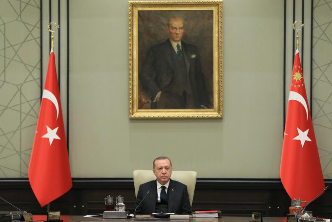 Na fotografiji vidimo turškega predsednika Recepa Tayyipa Erdogana, ki sedi pod velikim portretom ustanovitelja Republike Turčije Mustafa Kemala Atatürka. Erdogan v resnici ne sledi Atatürkovi poti, ampak skuša čim bolj razgraditi njegovo sekularno dediščino in vrniti Turke v obdobje pred Atatürkom. Erdoganovi vzorniki so v resnici otomanski sultani. | Foto: Guliverimage