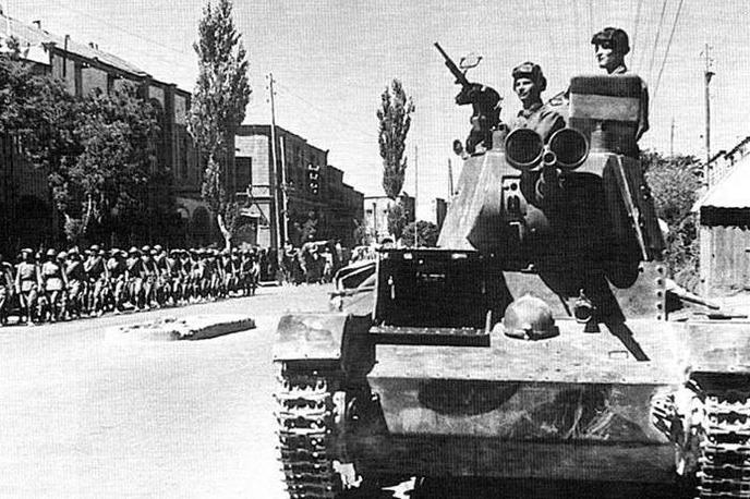 Sovjetski tanki v Tabrizu leta 1945 | Sovjeti so avgusta 1945 v Iran vdrli iz svojih zakavkaških in srednjeazijskih republik. Na fotografiji: sovjetska pehota in sovjetski tank v iranskem mestu Tabriz na severozahodu države. Sovjeti se po koncu vojne najprej niso hoteli umakniti iz Irana. Še več, spodbujali so odcepitev iranskih Azerbajdžancev in iranskih Kurdov od Irana. | Foto Wikimedia Commons