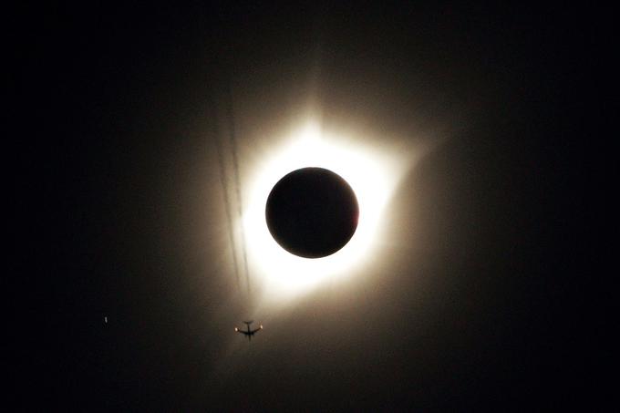 Fotograf, ki je v kraju Guernsey v ameriški zvezni državi Wyoming posnel popolni sončni mrk, je v objektiv ujel tudi potniško letalo, avgust 2017. | Foto: Reuters