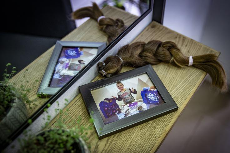Kitka, spletena iz podarjenih las, in zraven fotografija Brigitine hčerke Mije z lasuljami, ki so jih za slovenske otroke brezplačno izdelali v britanskem skladu Little Princess Trust. | Foto: Ana Kovač