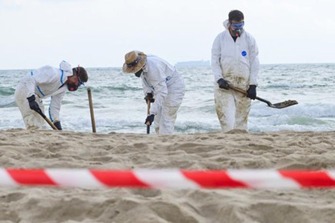 Plaža Valencia | Tehniki v belih zaščitnih oblekah so z lopatami odstranjevali oljne madeže. | Foto Profimedia