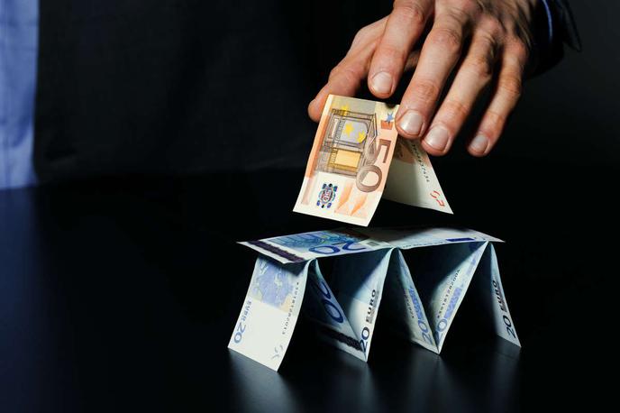 piramidna shema, denar, hišica iz kart | Nuvonex je v resnici zelo verjetno tako imenovana klavnica prašičev, vrsta piramidne sheme, ki jo pogosto upravljajo entitete iz jugovzhodne Azije, povezane s kitajskim organiziranim kriminalom. Klavnice prašičev so nazorno poimenovane piramidne sheme, pri katerih z obljubami o stabilnih visokih ali rednih pasivnih zaslužkih goljufi žrtve prek spletne komunikacije, ki pogosto poteka prek skupin v aplikacijah, kot sta Telegram ali WhatsApp, prepričajo, da jim zaupajo in v platforme sčasoma vložijo še več denarja ter rekrutirajo še več članov, saj bo njihov izkupiček tako še večji. | Foto Shutterstock