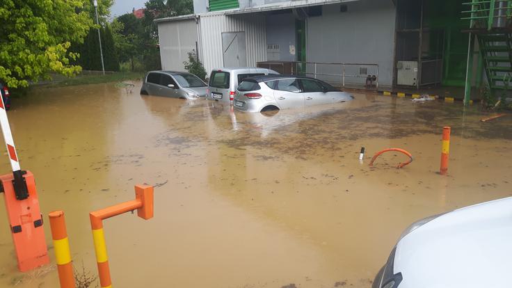 Voda je poplavila parkirišče pred trebanjskim zdravstvenim domom. Treh osebnih avtomobilov lastnikom ni uspelo pravočasno rešiti.  | Foto: Bralec Daniel Metelko