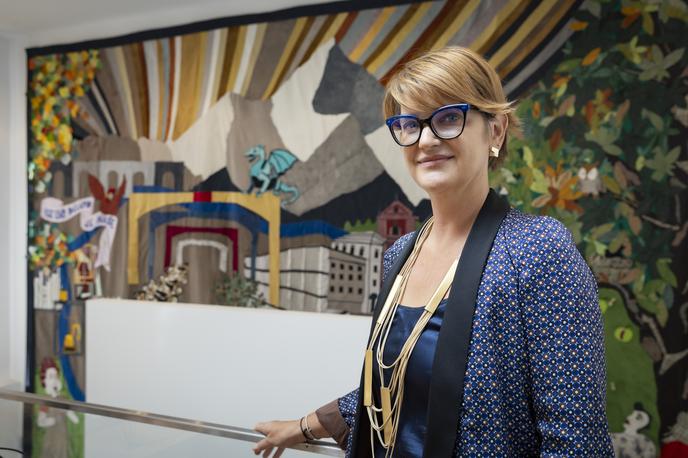 Center Rog. Renata Zamida | Center Rog je dostopen vsakomur. Tu se lahko obiskovalci učijo, ustvarjajo, izdelujejo, klepetajo, družijo. "Hiša je vsak dan polna in to nas najbolj veseli," je za Siol povedala direktorica centra Renata Zamida. V ozadju je ogromna skupnostna tapiserija Vse, kar delamo, je naše. Ideja je nastala oktobra 2023 ob vselitvi v prenovljeno stavbo. Motive je izrisala prva udeleženka rezidenčnega programa Centra Rog Lea Kirstein iz Nemčije. | Foto Bojan Puhek