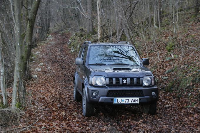 Jimny na polno zadiha z majhnimi bencinskimi pljuči, ko iz urejenih cestnih površin
zapelje po kolovozih med drevesa. Takrat luči ne potrebuje, zato dnevnih sploh nima. | Foto: Aleš Črnivec