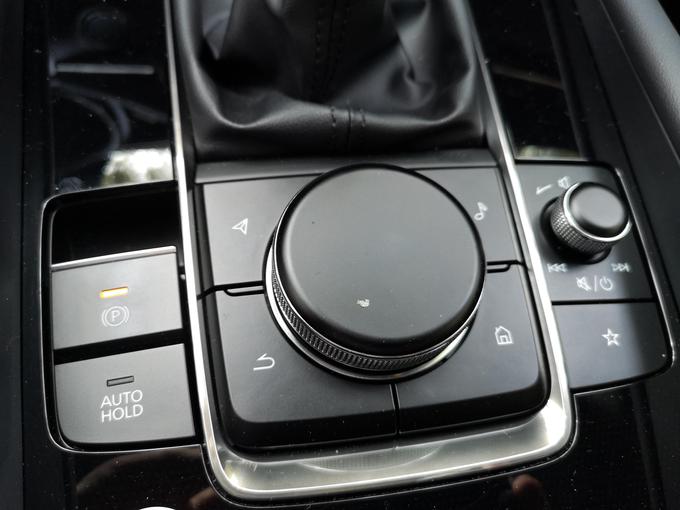Vrtljiv gumb (s funkcijskim pritiskom navzdol) je ključ do komunikacije z infozabavnim sistemom. Tudi na tem področju je Mazda naredila korak naprej. | Foto: Gregor Pavšič