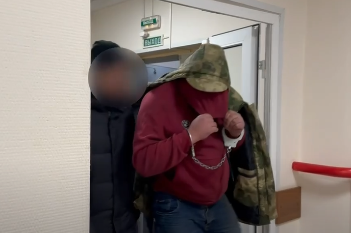 Morilec Rusija | Osumljenec za umor devetletnega dečka, Rus Petr Žilkin, ob privedbi na policijsko postajo v Sankt Peterburgu.  | Foto Sledcom
