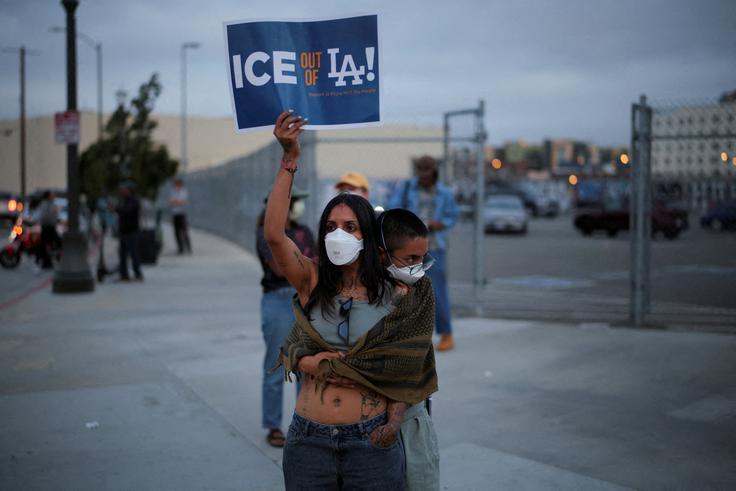 Protestnica s transparentom: "ICE ven iz Los Angelesa!" | Foto: Reuters