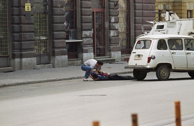 Neznani moški pomaga žrtvi ostrostrelca. Fotografija je bila posneta 14. junija 1995. | Foto: Guliverimage/Vladimir Fedorenko