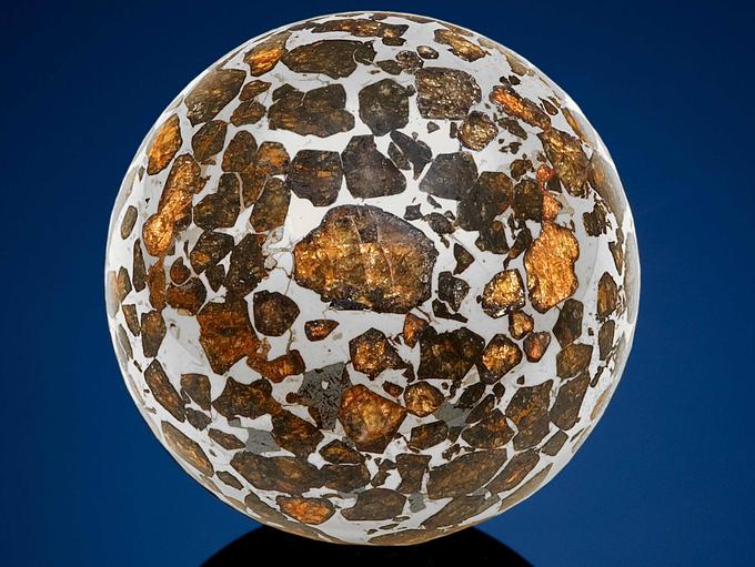 Sredica meteorita je kovinska (zlitina železa in niklja), rumenkasti otočki na površini pa so kristali minerala olivina (magnezijev-železov silikat). | Foto: 
